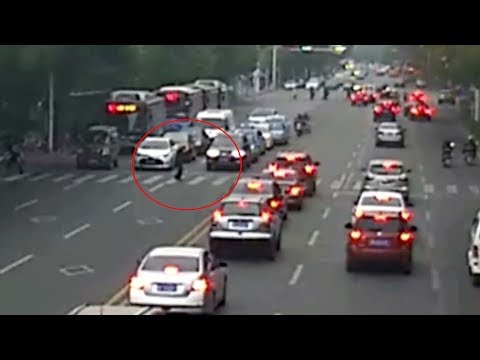 dozens of cars guard a pedestrian